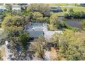 Aerial view showcases a private pool, lush landscaping, and serene waterfront location, enhancing this home's appeal at 2416 S 46Th St, Tampa, FL 33619