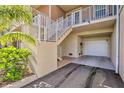 Townhouse elevation highlighting ground level garage, stairs to covered entrance, and lush landscaping at 3282 Mangrove Point Dr, Ruskin, FL 33570