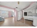Open-concept kitchen with white cabinets and views into the living area at 3348 Clydesdale Dr, Holiday, FL 34691
