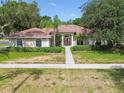 Charming single-story home boasting a tile roof, manicured landscaping, and a sidewalk leading to the front entrance at 3351 Bristol Pl, Tarpon Springs, FL 34688