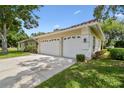 Spacious three-car garage with white doors, providing ample parking and storage space at 3351 Bristol Pl, Tarpon Springs, FL 34688