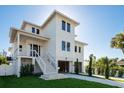 Inviting three-story home featuring a covered porch, neat landscaping, and ample under-house parking at 3752 Arkansas Ne Ave, St Petersburg, FL 33703