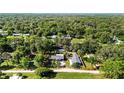 Expansive aerial view highlighting property's location surrounded by lush greenery and neighboring homes at 39252 Kimberly Ave, Zephyrhills, FL 33540