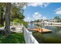 Waterfront backyard featuring a private dock with seating, a white picket fence, and lush landscaping at 4315 Flexer Dr, Hernando Beach, FL 34607