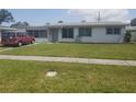Charming single-story home with a well-maintained lawn and red van parked in the driveway at 4409 W Wyoming Ave, Tampa, FL 33616