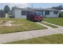 Single-story home with a well-maintained lawn, sidewalk, and red van parked in the driveway at 4409 W Wyoming Ave, Tampa, FL 33616