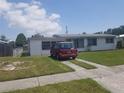 Single-story home with a well-maintained lawn, sidewalk, and red van parked in the driveway at 4409 W Wyoming Ave, Tampa, FL 33616