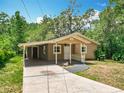 Cozy one-story home with a convenient carport and a shaded front entrance with stylish railing at 473 Forest Ave, Brooksville, FL 34601