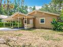 Inviting single-story home featuring a covered carport and a quaint, landscaped front yard at 473 Forest Ave, Brooksville, FL 34601