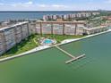 Aerial view of waterfront condo with swimming pool and pier highlighting the coastal lifestyle at 5130 Brittany S Dr # 604, St Petersburg, FL 33715