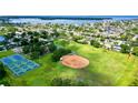 Aerial view of neighborhood with tennis courts, baseball field, and a view of the water at 5340 Denver Ne St, St Petersburg, FL 33703