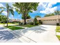 Single Gathering home with well-manicured front yard, mature landscaping, and attached garage at 5524 Salem Square N Dr, Palm Harbor, FL 34685
