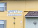 Close-up shot of building with 'Waves 600' signage, windows, and the building's color at 600 71St Ave # 18, St Pete Beach, FL 33706