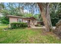 A cozy single-story property featuring a wooden porch and lush greenery at 6406 Congress St, New Port Richey, FL 34653