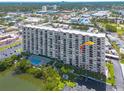 Scenic view of the condo building, pool, and water with mature trees surrounding at 7050 Sunset S Dr # 1401, South Pasadena, FL 33707