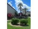 Community entrance sign framed by beautiful landscape in RoseTree Village at 7360 Ulmerton Rd # 16A, Largo, FL 33771