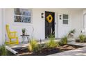 Inviting front porch featuring a stylish wreath, modern lighting, and tasteful decor, exuding curb appeal at 75 New Jersey Dr, Dunedin, FL 34698