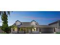 Charming home featuring a manicured lawn, mature palm trees, and a spacious two-car garage at 8711 Thornwood Ln, Tampa, FL 33615
