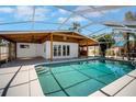 Inviting screened-in pool area perfect for relaxation and outdoor entertaining with wooden ceiling at 8711 Thornwood Ln, Tampa, FL 33615