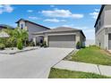 A single-story home featuring a two-car garage and meticulously maintained landscaping at 872 Olive Conch St, Ruskin, FL 33570