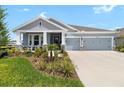 Charming single-story home with a three-car garage, inviting front porch, and beautifully landscaped yard at 8916 Windlass Cv, Parrish, FL 34219