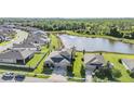 An aerial view of a residential neighborhood with a tranquil pond and lush green surroundings at 12745 Moorish Pl, Spring Hill, FL 34610