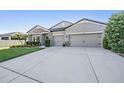 Charming single Gathering home featuring a stone facade, gray stucco and a long driveway at 12745 Moorish Pl, Spring Hill, FL 34610