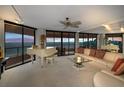 Bright living room with floor to ceiling windows, ocean view, white piano and comfortable seating at 1340 Gulf Blvd # 16A, Clearwater Beach, FL 33767