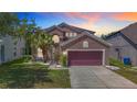 Charming two-story home featuring a well-manicured lawn, a two-car garage and mature landscaping at 14137 Wake Robin Dr, Brooksville, FL 34604