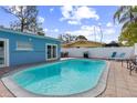 Backyard pool with lounge chairs, grill, and a privacy fence creates a private oasis for relaxation and outdoor enjoyment at 1818 Indian Rocks Rd S, Largo, FL 33774