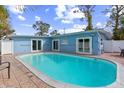 Private backyard pool with patio area, white privacy fence, and lush landscaping providing a serene outdoor space at 1818 Indian Rocks Rd S, Largo, FL 33774