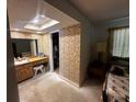 Bathroom featuring wood cabinets, an adjacent walk-in closet, and wallpaper at 213 Mahogany Dr, Seffner, FL 33584