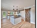 Bright kitchen featuring a large island, stainless steel appliances, and a rustic sliding barn door at 213 Mahogany Dr, Seffner, FL 33584