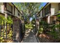 Landscaped entryway with brick pillars and a black metal gate at 2665 Sequoia Ter # 306, Palm Harbor, FL 34683