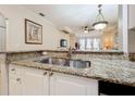 Close-up of the kitchen sink area with granite countertops and a view into the living area at 2724 Via Murano # 615, Clearwater, FL 33764