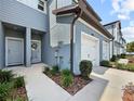 Home's entrance with gray door, a decorative wreath, and manicured landscaping at 2874 Deer Pine Trl, Land O Lakes, FL 34638