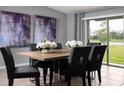 Modern dining area featuring stylish seating for six, contemporary artwork, and sliding glass doors leading to the outdoor area at 4015 86Th E St, Palmetto, FL 34221