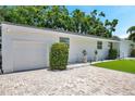 Paver driveway leading to a white home with an attached garage and manicured landscaping at 4019 W Bay To Bay Blvd, Tampa, FL 33629