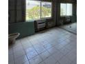 Under-construction bathroom featuring tiled floor, large window, and air conditioning unit at 4129 Dolphin Dr # 103, Tampa, FL 33617