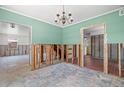 Dining area featuring a chandelier and an open layout leading to other rooms, with exposed studs at 417 66Th S Ave, St Petersburg, FL 33705