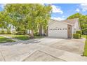 Lovely single-Gathering home featuring a spacious driveway, a manicured lawn, and an attached two-car garage at 5434 Wellfield Rd, New Port Richey, FL 34655
