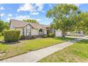 Charming one-story home featuring a well-maintained lawn, mature landscaping, and an attached two-car garage at 5434 Wellfield Rd, New Port Richey, FL 34655