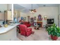 Inviting living room featuring high ceilings, plush red furniture, a cozy fireplace, and ample natural light at 5465 Chestnut Ridge Rd, Dade City, FL 33523