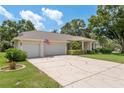 Inviting single-story home with a three-car garage, spacious driveway, and well-kept landscaping at 627 Belted Kingfisher N Dr, Palm Harbor, FL 34683