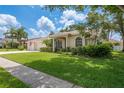 Charming single-story home with well-manicured lawn and mature landscaping at 627 Belted Kingfisher N Dr, Palm Harbor, FL 34683