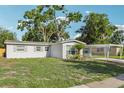 Single-story home with a well-manicured lawn and a covered carport at 7110 Bonito St, Tampa, FL 33617
