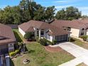 Aerial view of a cozy one-story home with manicured lawn and driveway, nestled among mature trees at 9200 Halberg Dr, Hudson, FL 34669