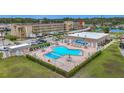 Aerial view of the community pool with a unique shape, surrounded by lush landscaping and lounge chairs at 1 Boca Ciega Point Blvd # 215, St Petersburg, FL 33708