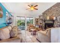 Cozy living room featuring a stone fireplace, tile flooring, and sliding doors to the patio at 1024 Dockside Dr, Lutz, FL 33559