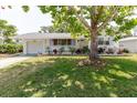 Charming single-story home with a lush front yard and mature shade tree at 103 N Meteor Ave, Clearwater, FL 33765